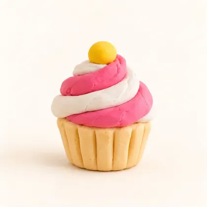 A clay cupcake with a pink and white swirl, made by a child