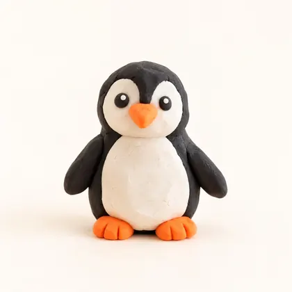 A clay penguin with a white belly and orange beak, made by a child