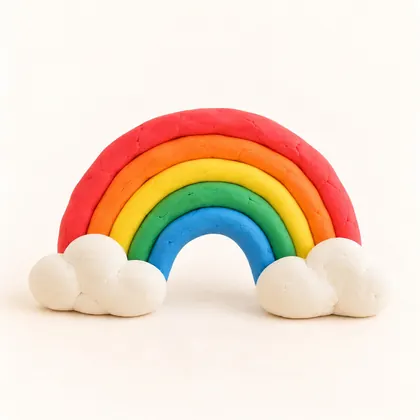 A clay rainbow with white clouds, made by a child